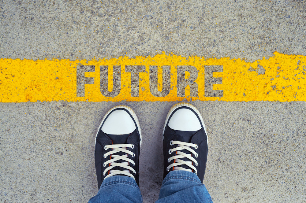 Person standing at a yellow line on the ground with the word 'FUTURE' written on it.